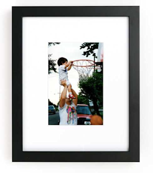Framed photo of dad holding up son to dunk basketball