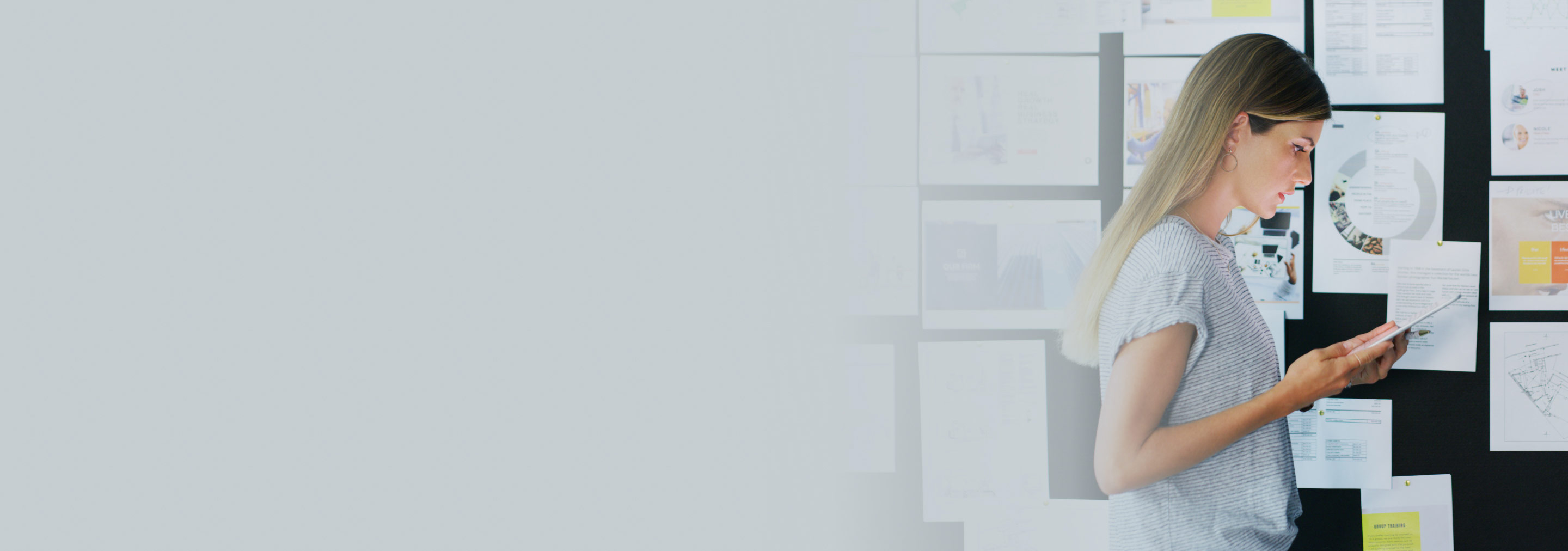 Tablettia ideataulun edessä katseleva henkilö