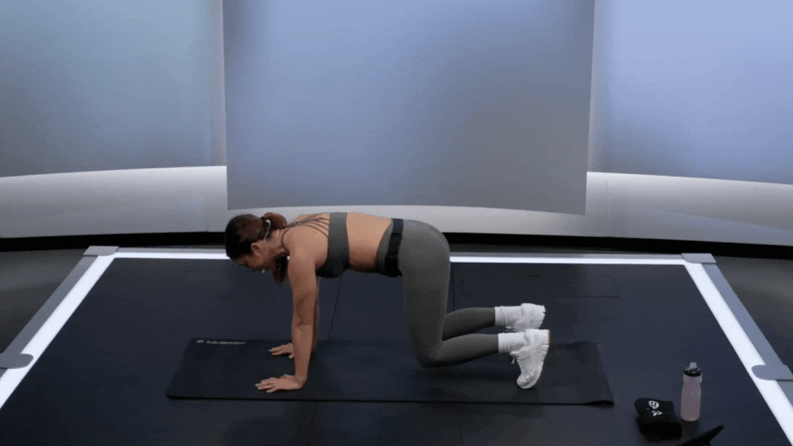 Peloton instructor Emma Lovewell demonstrates a bear plank to Downward-Facing Dog during a core strength class.
