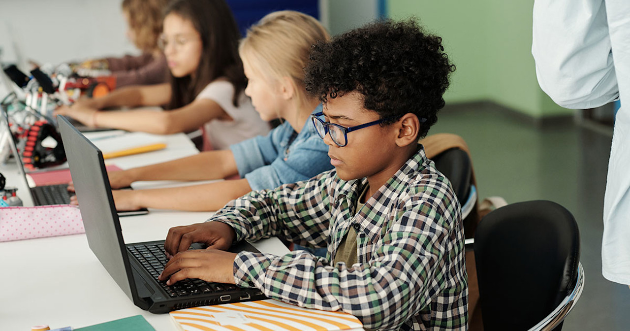Basisschoolleerlingen werken op laptops Schoolboy-working-on-laptop