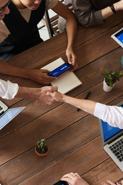 twee mensen om de tafel schudden elkaar de hand samenwerking