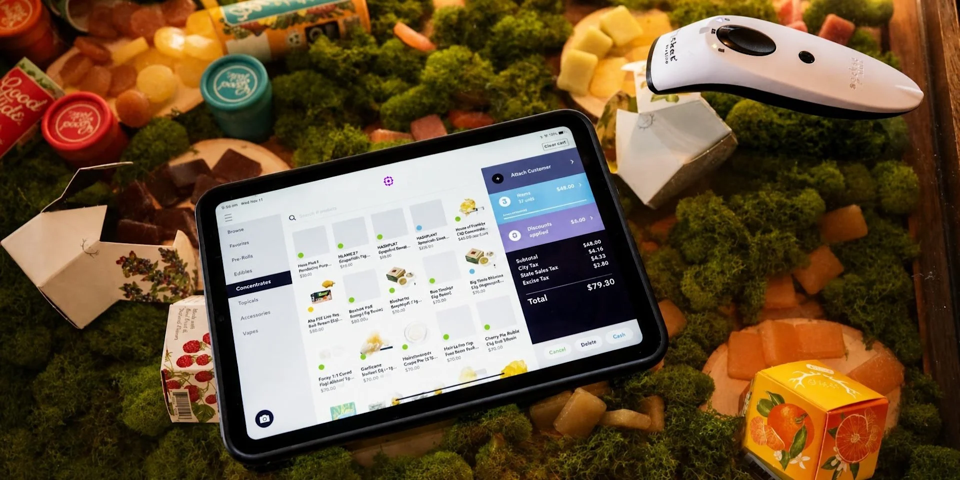 Meadow's point of sale open to the concentrates menu on an iPad, surrounded by cannabis products with a handheld barcode scanner.