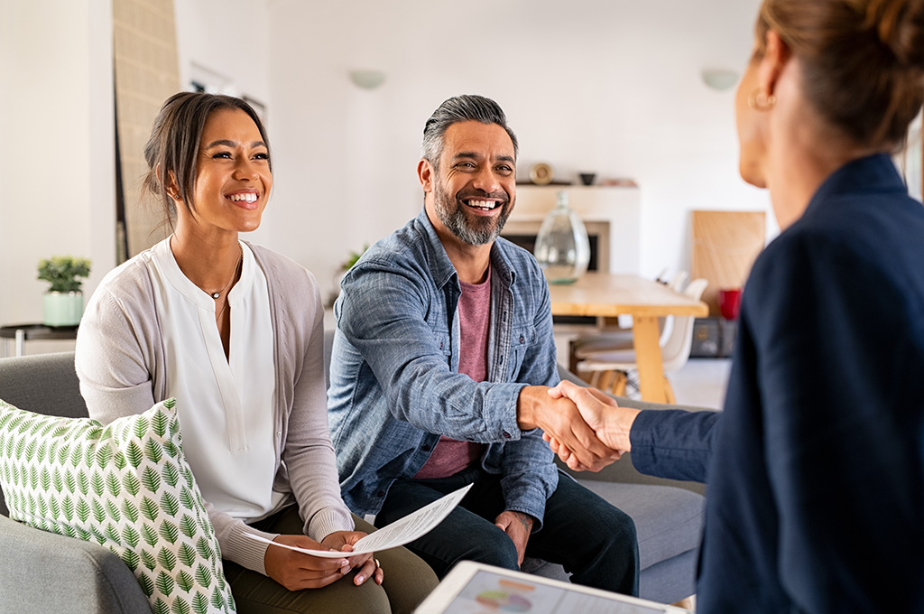A veteran couple shakes hand with an insurance agent after picking their best choice for life insurance.
