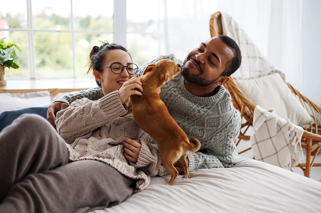 A veteran and her husband play with their dog at home