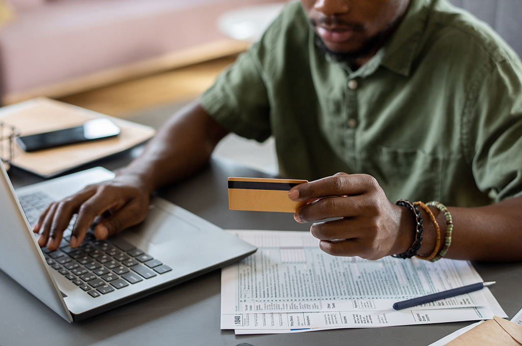 Veteran holding a credit card going over his credit card debt and wondering how to manage payments.