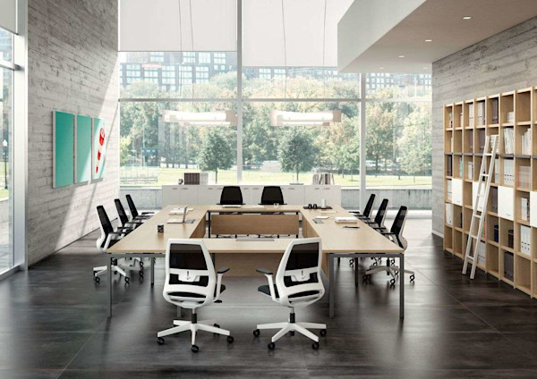 An executive conference table with ergonomic modern office task chairs in a open room with natural light