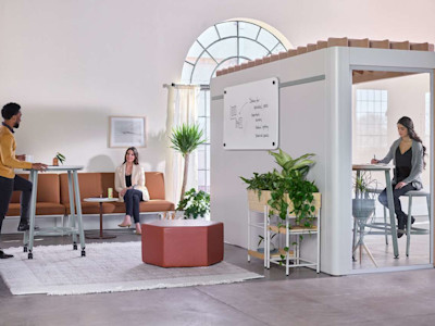 Modern office is broken into zones with cubicles in one area and a relaxed coworking space in another.