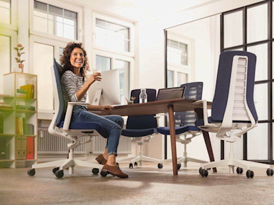 woman sitting on a comfortable office chairin a brightly lit conference room