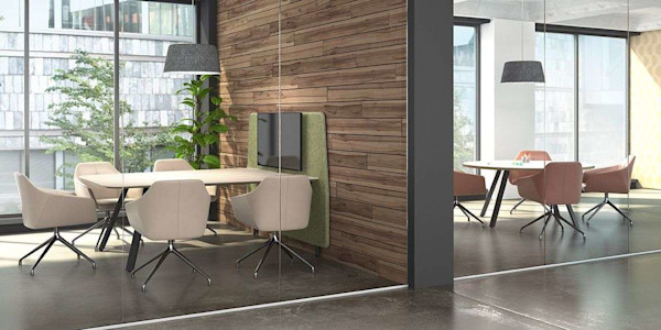 Round conference table and square conference table in an office space with ergonomic seating and natural light
