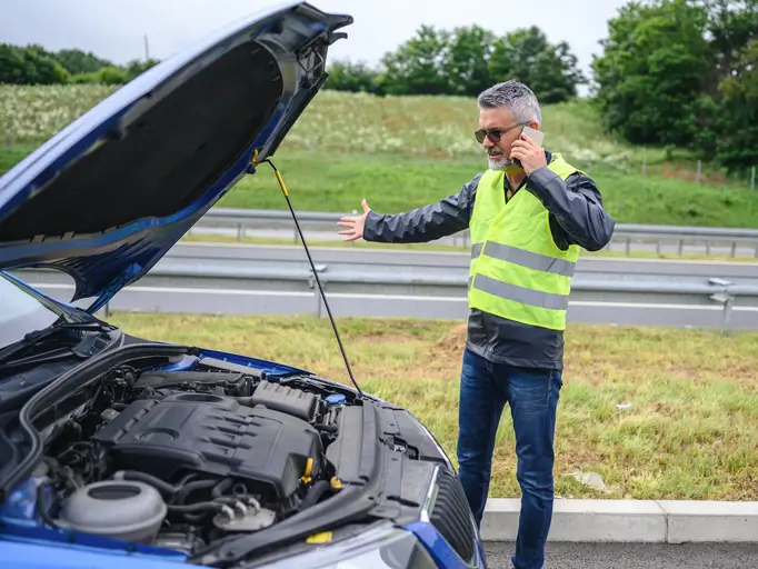 Conductor usando chaleco reflectante durante una emergencia vial en carretera chilena