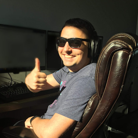 Gabriel Laroche wearing sunglasses at his computer desk, smiling with a thumbs up.