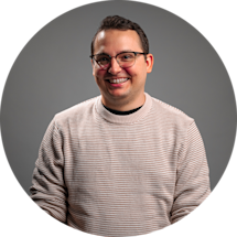 Gabriel Laroche in Christmas sweater, smiling in an office.