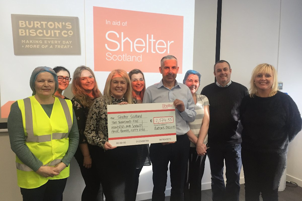 The team at Burtons Biscuits holding a cheque for Shelter Scotland