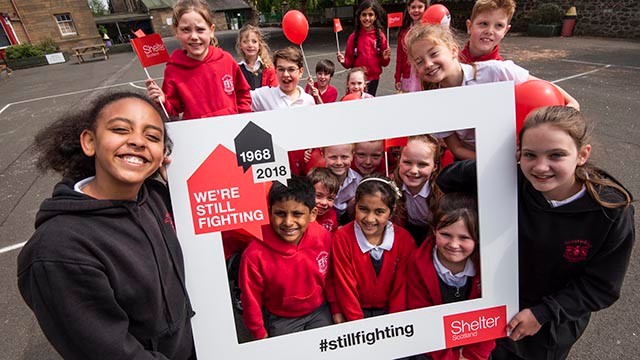 School children with #stillfighting campaign sign