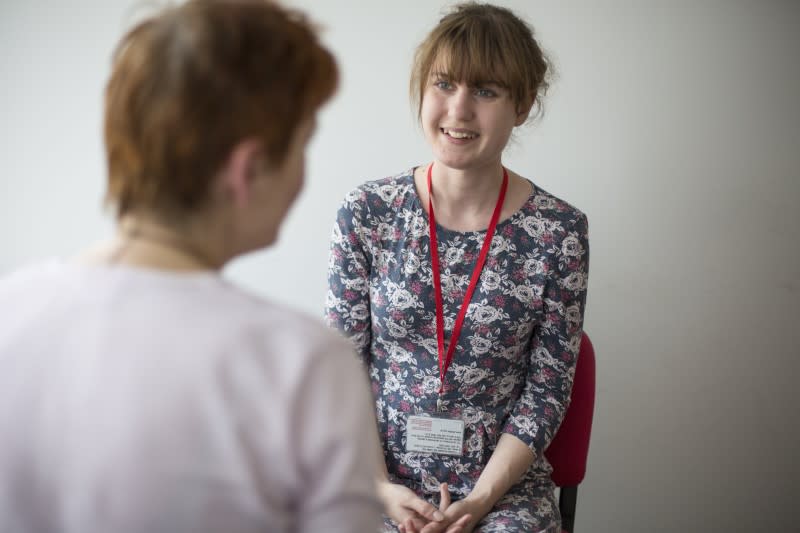 A Shelter Scotland adviser, smiling and talking to a client