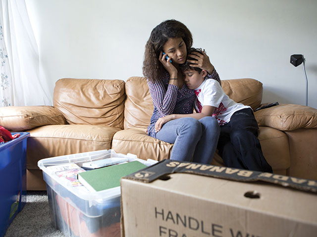 Mother and son. Phone. Moving boxes.