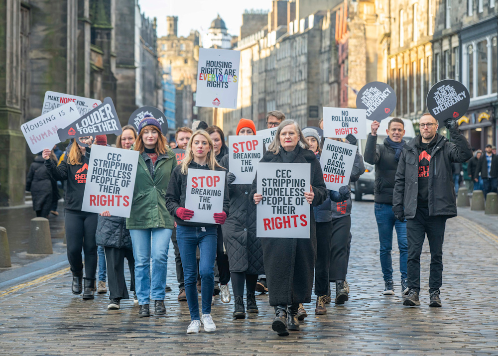 A group of Shelter Scotland staff in Edinburgh, holding placards