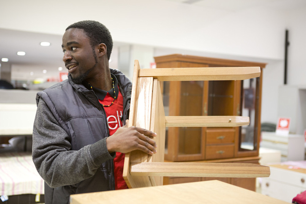Man in a Shelter shop holding a table