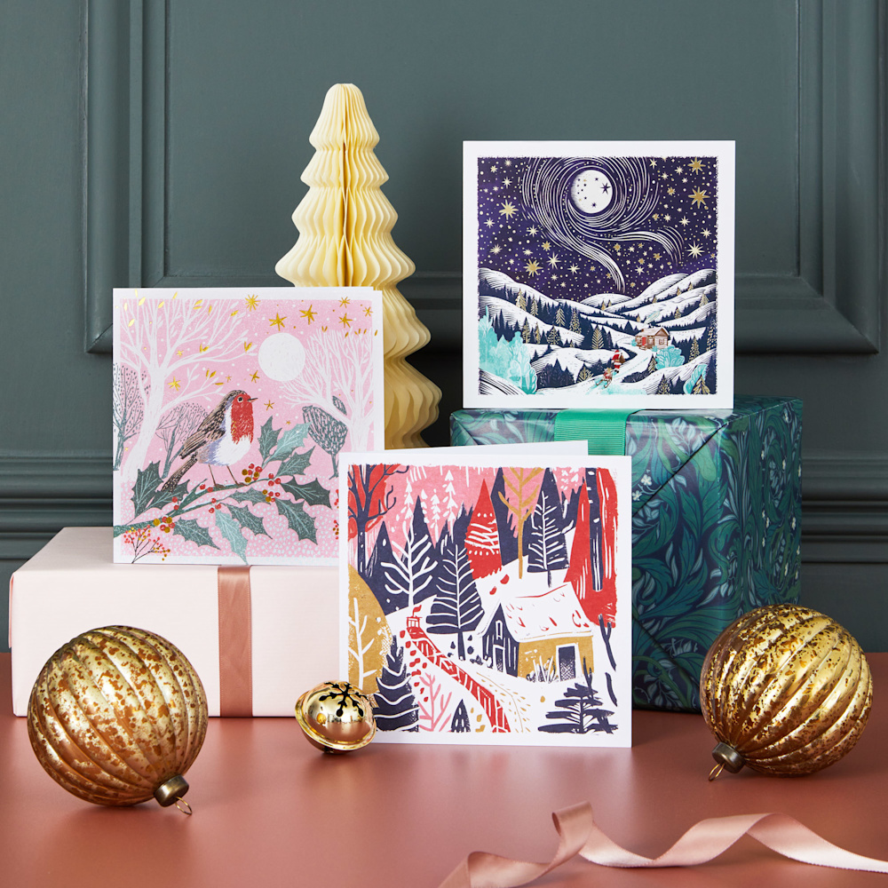 A selection of Christmas cards with designs including a robin and lino cuts of snowy festive woods.