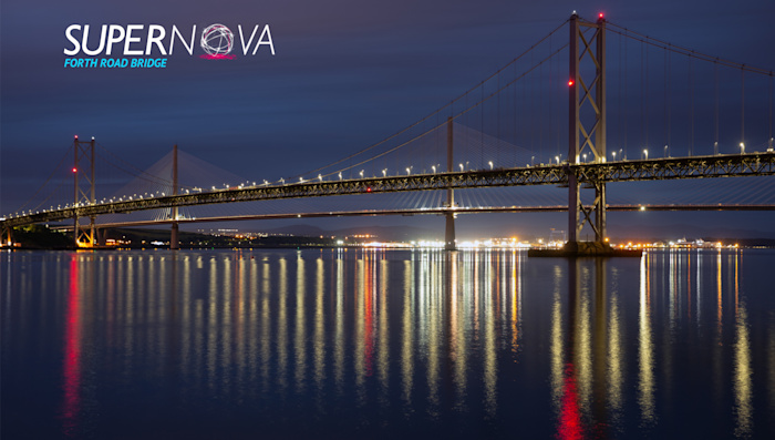 Forth Road Bridge lit up at night with lights reflecting on the water. Text reads 'Supernova Forth Road Bridge'.