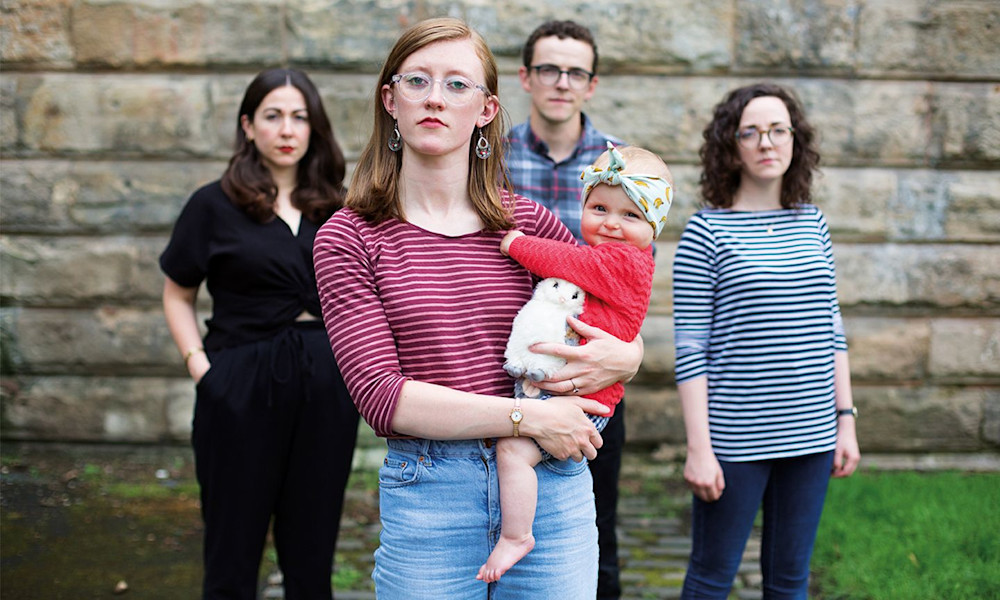 Serious adults with laughing baby
