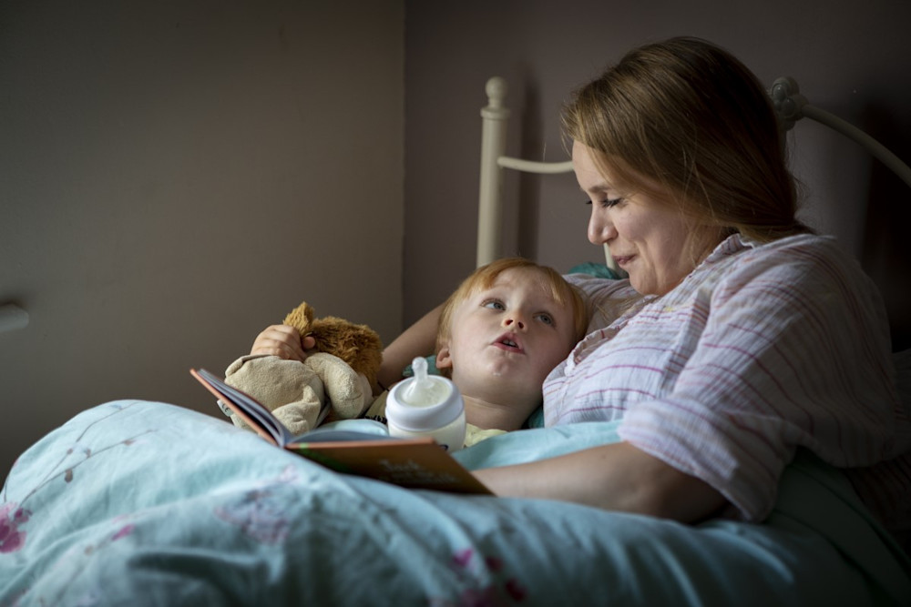 Georgina reads a story to her son tucked up in bed