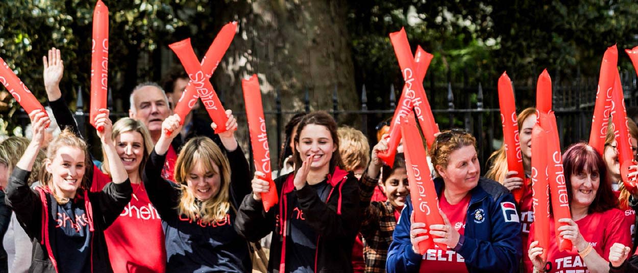 A group of Shelter supporters cheering on event participants at a fundraising race
