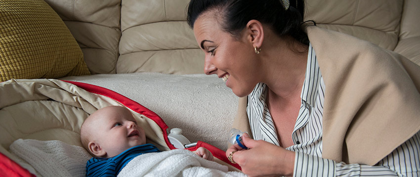 A mother looks at her smiling baby