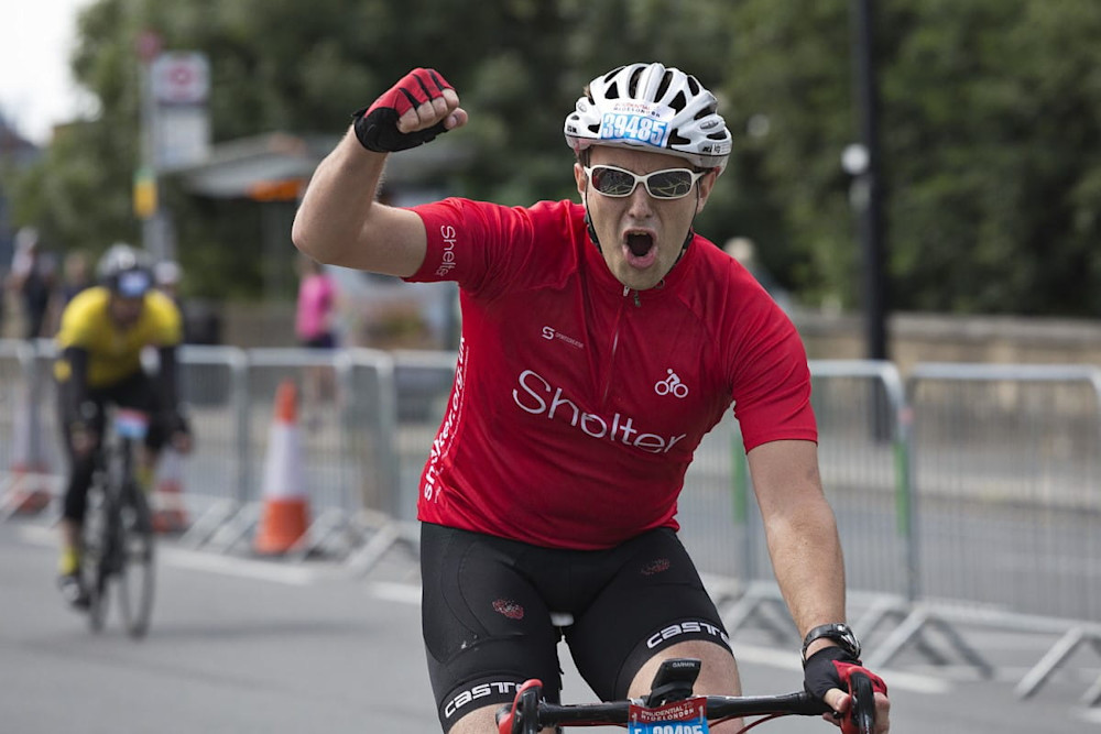 A cyclist pumps his fist in triumph