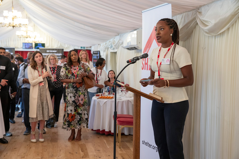 Image of a young black woman giving a speech on racism in housing