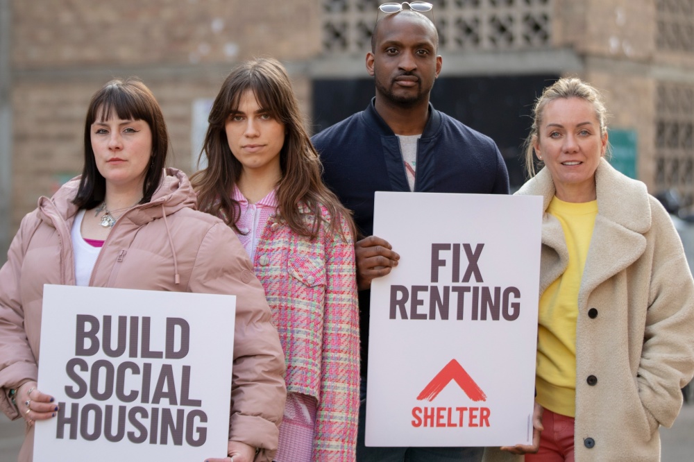 Three women and a man hold signs saying 'fix renting' and 'build social housing'