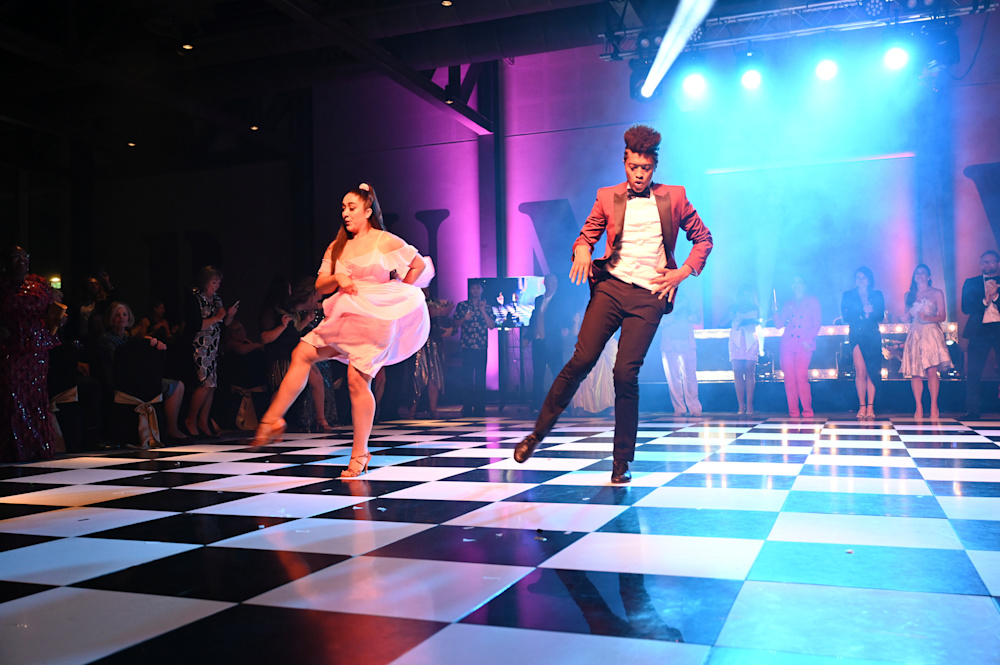 A female and male dancer on the dancelfloor under bright lights