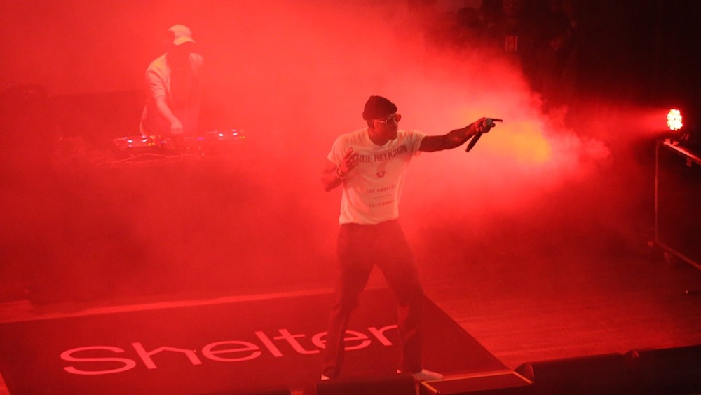 A performer onstage at a music event to raise funds for Shelter