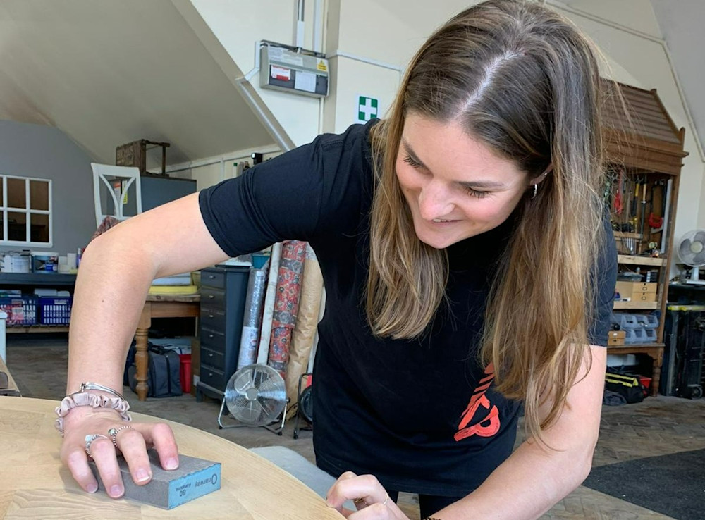 A person smiling while furnishing furniture