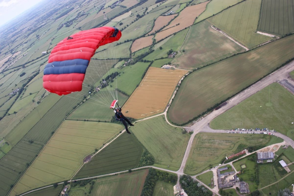 A person skydives over a field