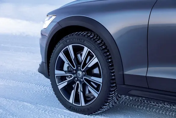 Close up of a car tyre making tracks in the snow