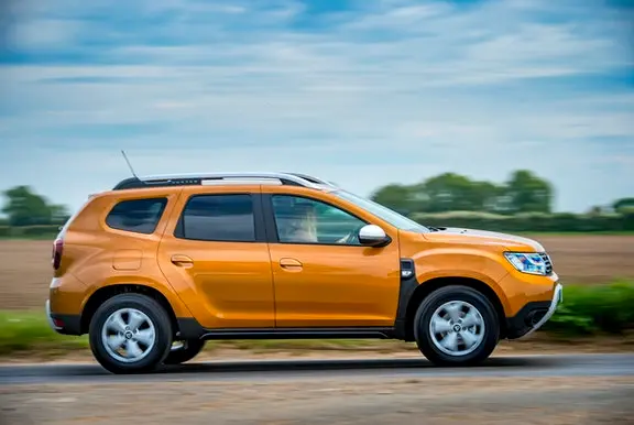 The side exterior of a gold Dacia Duster