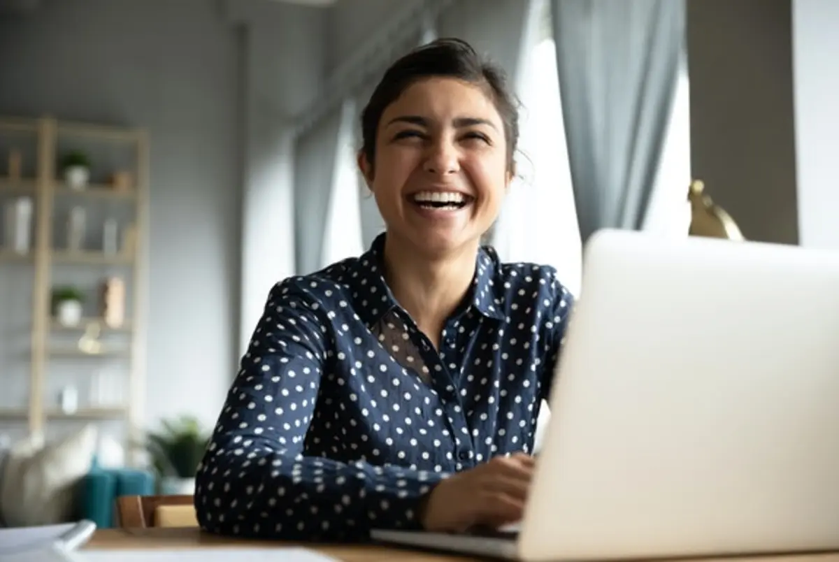 Woman on laptop laughing