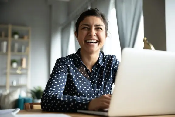 Woman on laptop laughing