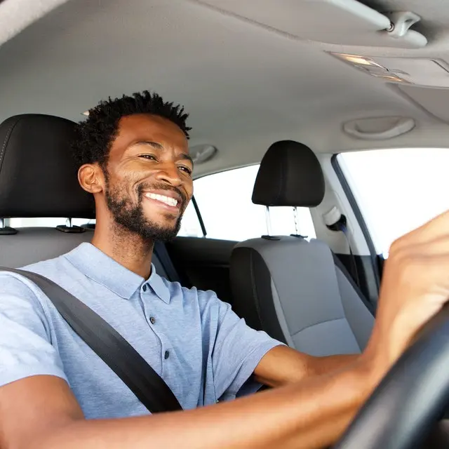 Smiling man driving a car