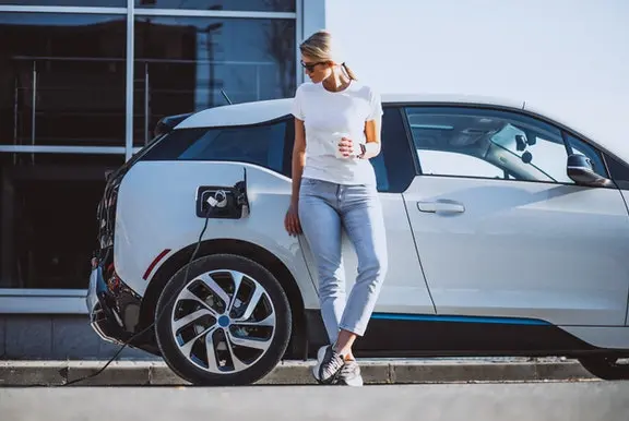 A woman charging her electric car