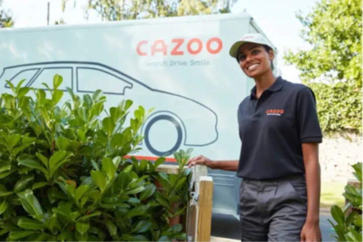 Cazoo car delivery driver smiling by Cazoo delivery van
