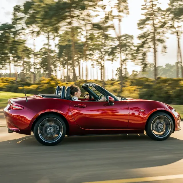 The side exterior of a red Mazda MX-5
