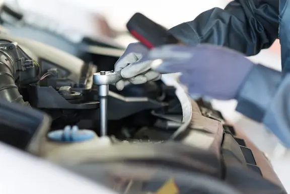 Car mechanic using a socket wrench