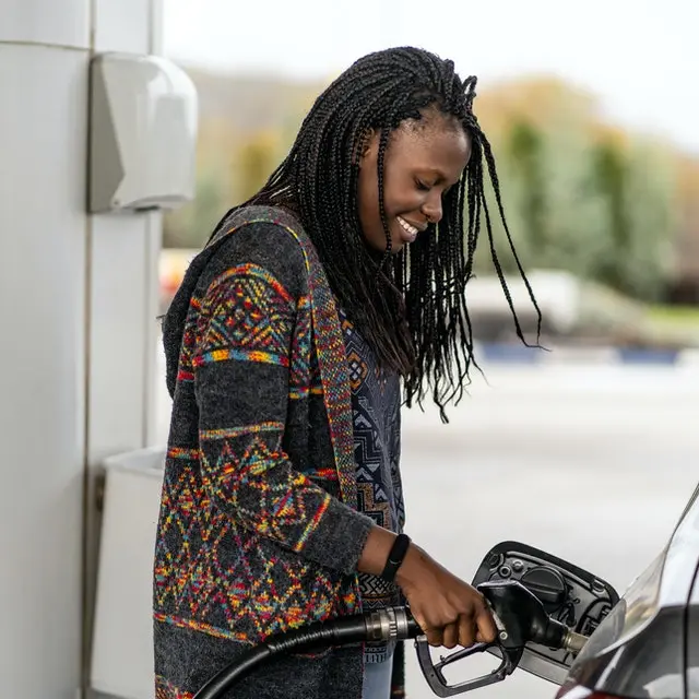 Lady at fuel pump filling up her car