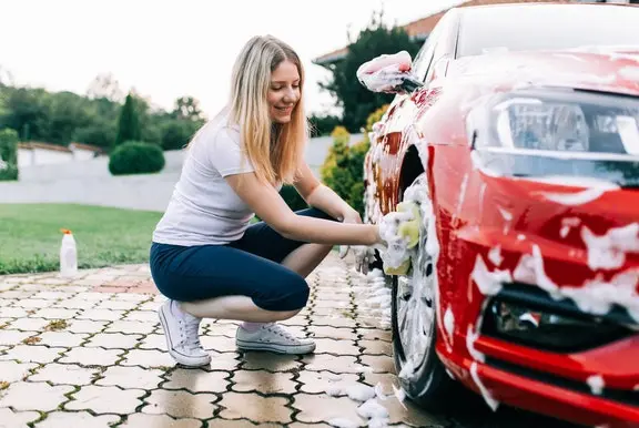 Woman washing red car