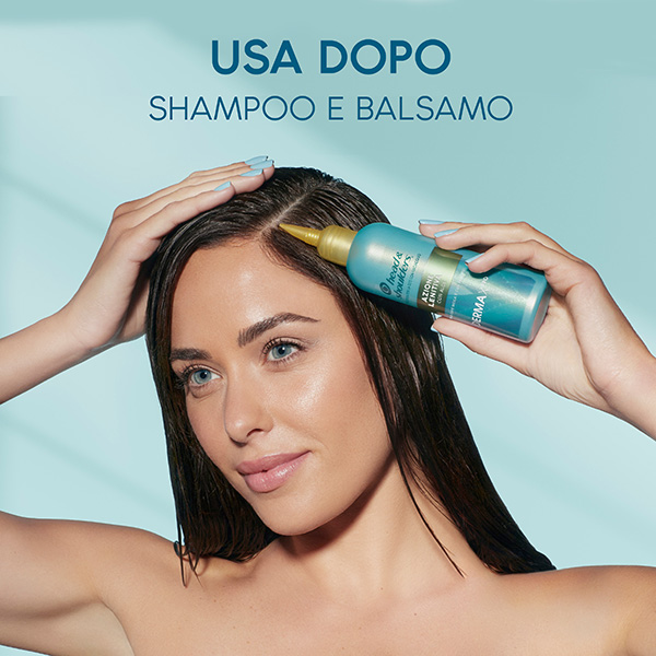 Una donna giovane con i capelli lunghi e bagnati dopo la doccia si mette il balsamo H&S Derma X Pro sul cuoio capelluto 
