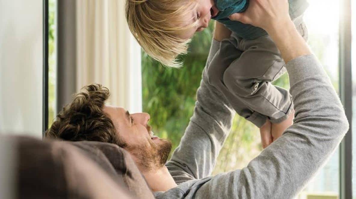 A man holding up his smiling son