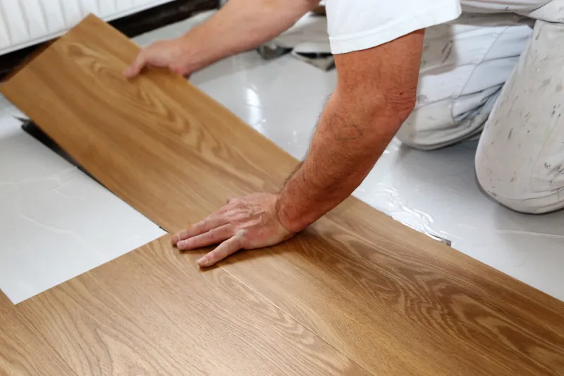 Handwerker verlegt Klick-Vinyl als Bodenbelag