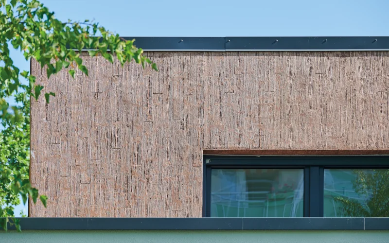 strukturierte rötliche Fassade mit Fenstern